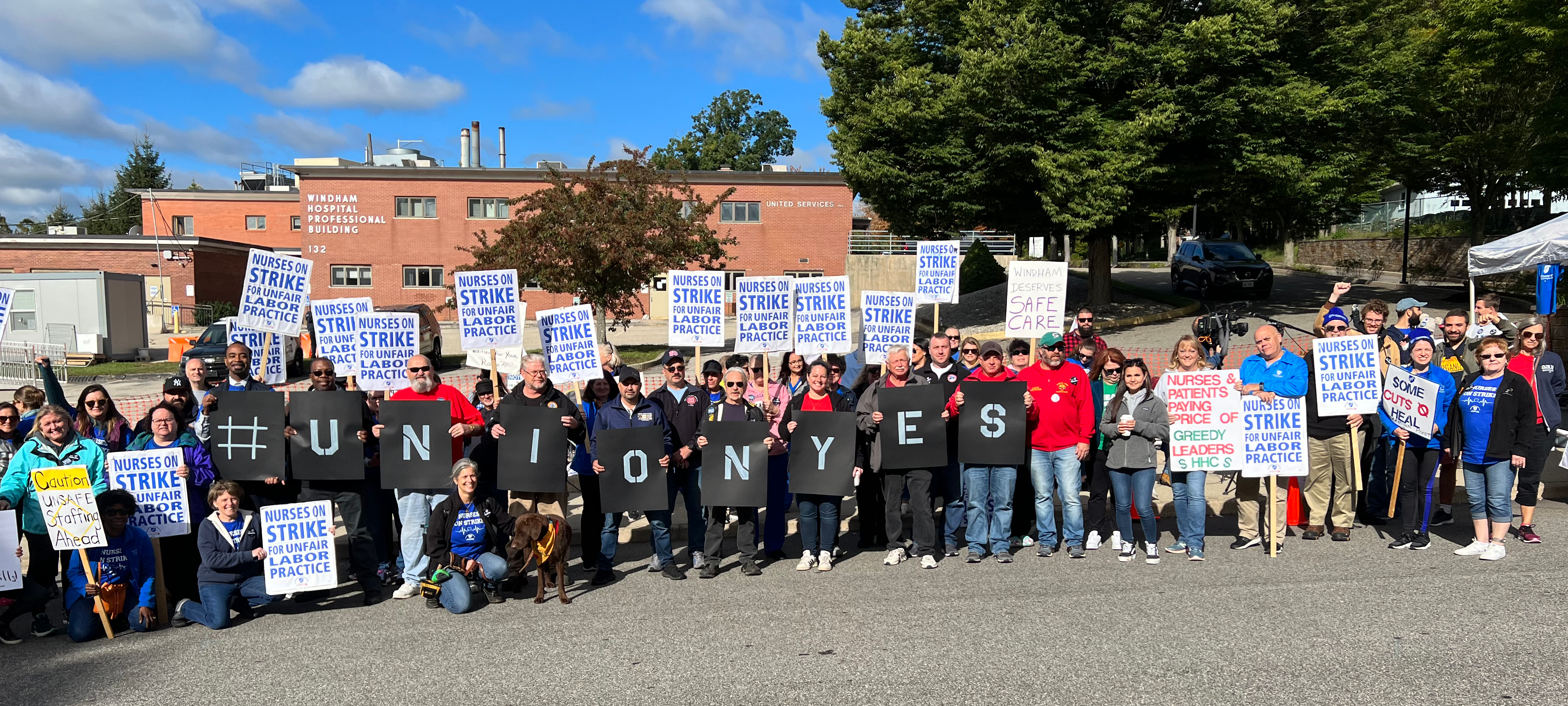 Union members hold up signs reading 